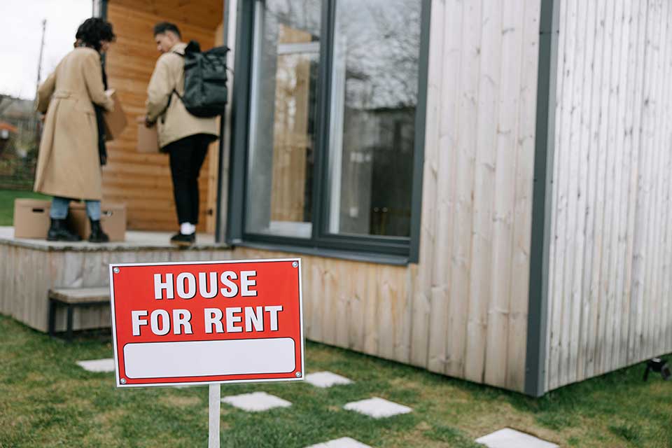 People carrying boxes into a house after signing a tenancy agreement